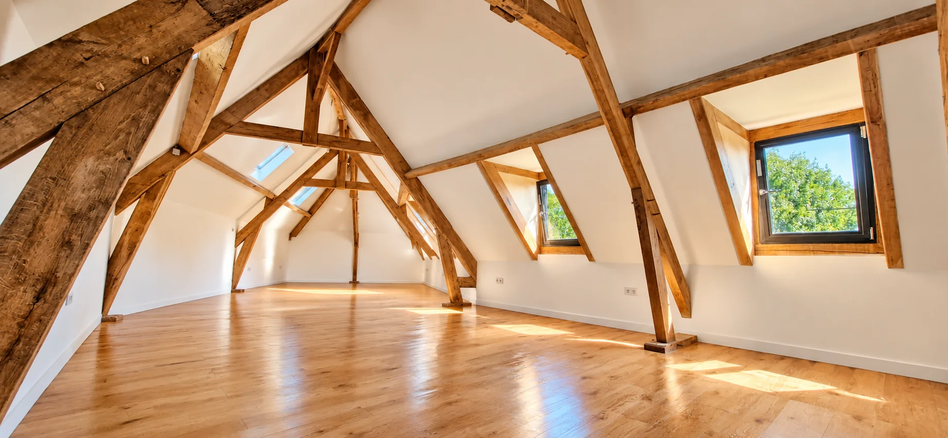Combles rénovés avec poutres apparentes et parquet