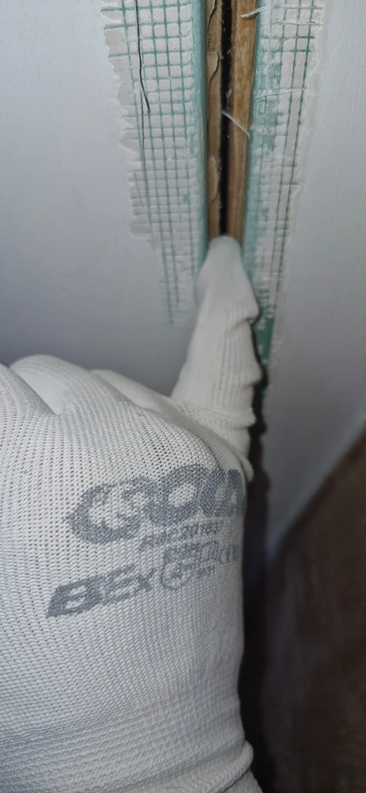 Opened plasterboard joint showing the original mesh reinforcement
