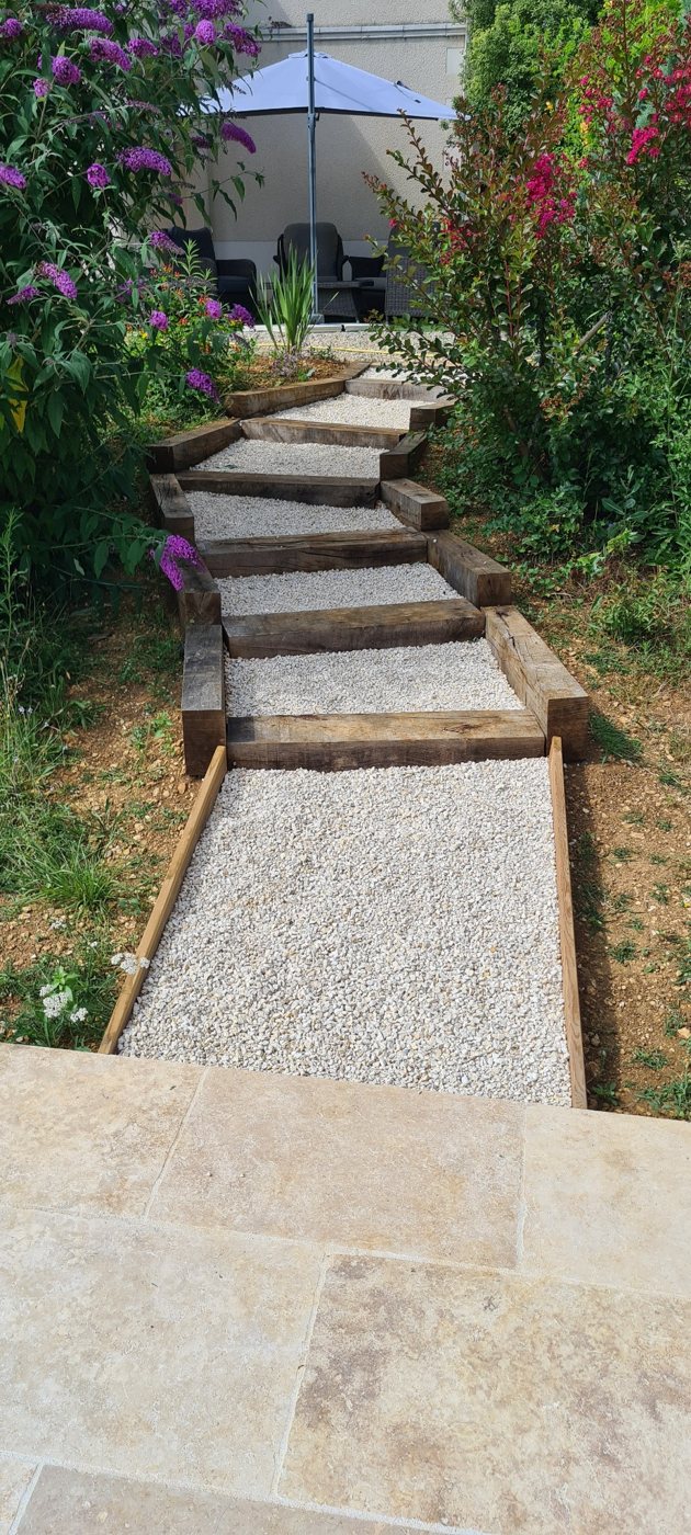 Completed timber garden steps and gravel pathway leading to a patio
